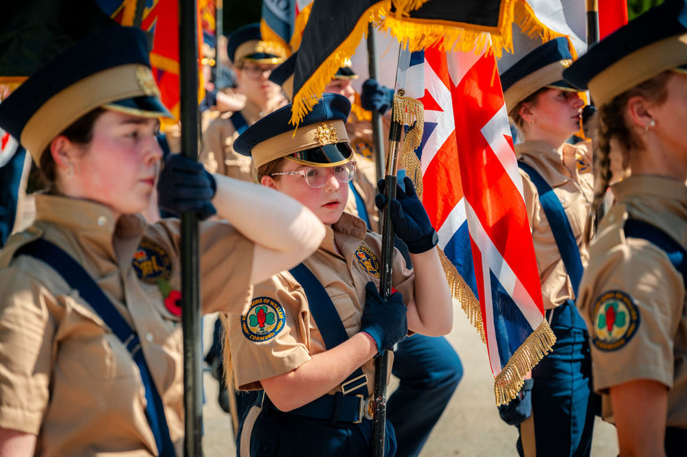 Yung cadets in military uniforms holding banners and union jacks to celebrate 109 years of the Thiepval Memorial