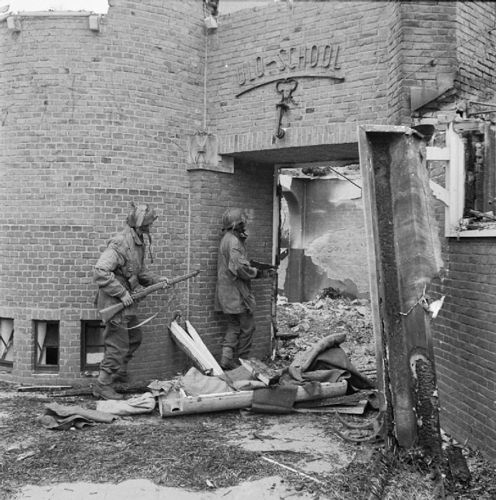 British troopers sweep a ruined German school for snipers.