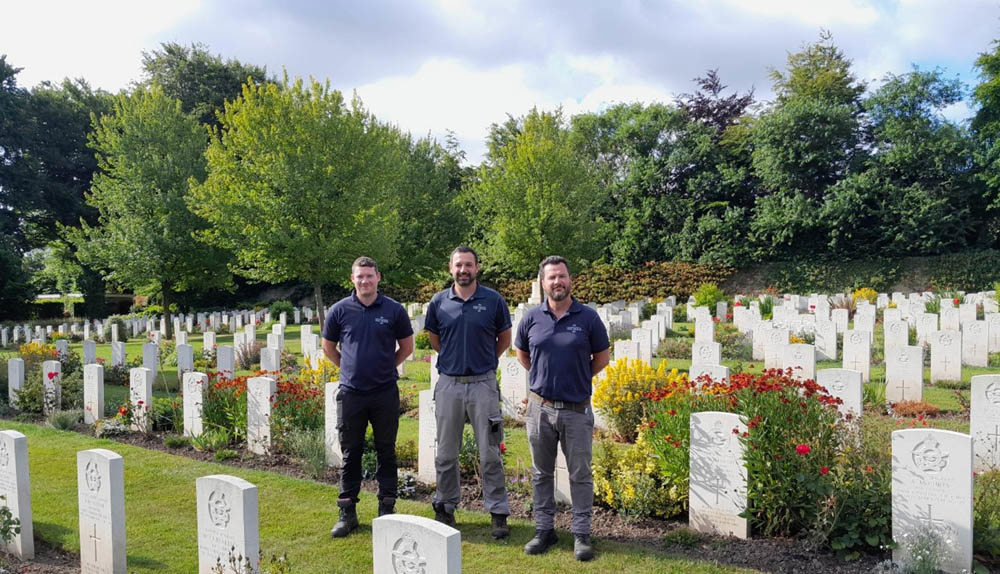 Three CWGC Gardeners posing with their arms behind their backs in Harrogate (Stonefall) Cemetery.