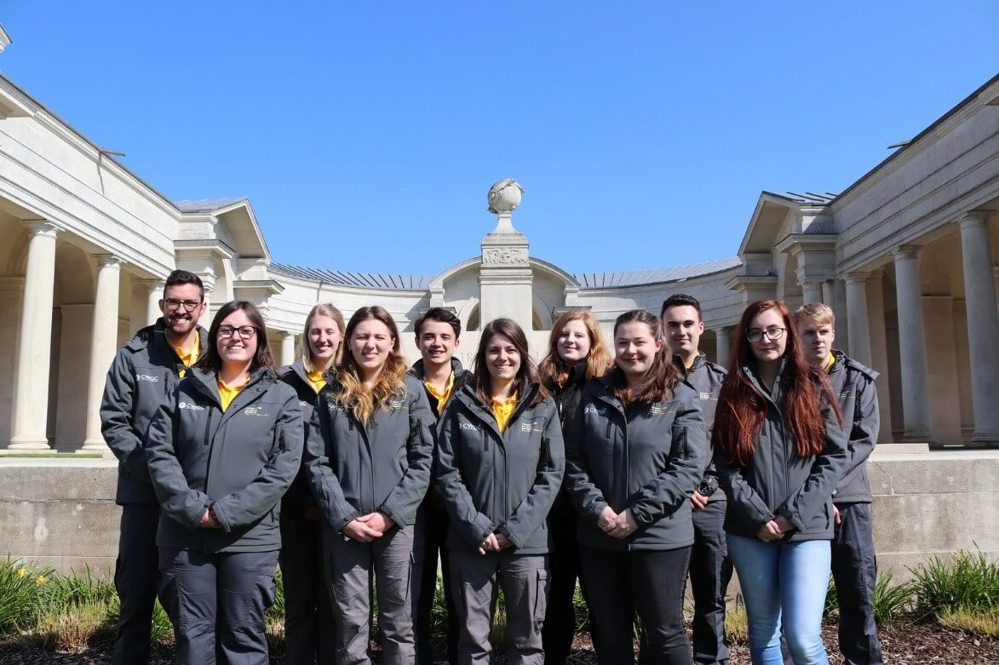 Interns standing outside a war memorial